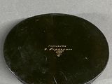 a small black plate that has a gold emblem on it