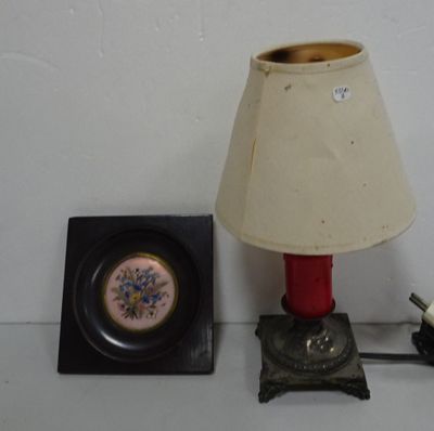 une lampe placée à côté d'un tableau accroché au mur