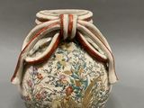 a vase with a bow on the top of it