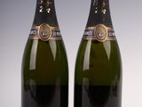 two bottles of champagne sitting next to each other on a table