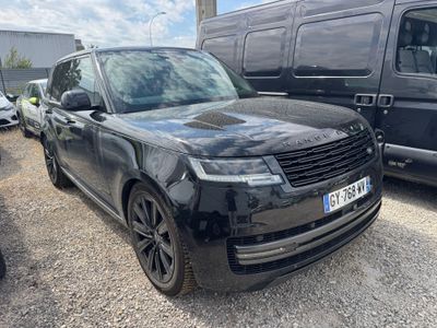 the black range rover is parked in a parking lot next to a van