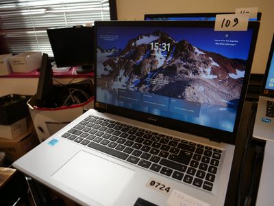 a laptop computer sitting on top of a desk in a room