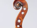 a close up of the back of a violin with a fiddle in the foreground