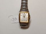 une image représentant une montre en argent et en or posée sur une surface blanche