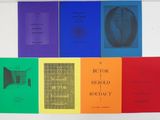 several books are lined up in a row on a white surface