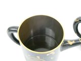 a black and gold cup with a handle on a white background