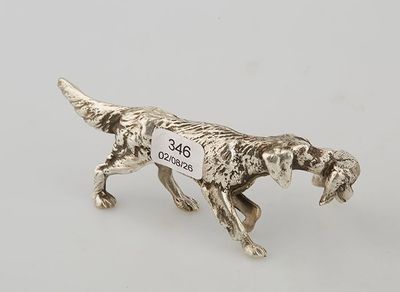 a silver figurine of a dog with a tag on it