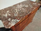 a marble top on a wooden dresser in a room