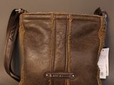 brown leather cross body bag with a small tag on the side