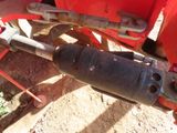 a close up of a red tractor with a hose attached to it