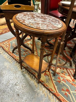 une table au plateau en marbre posée sur un tapis dans une pièce