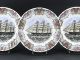 trois assiettes ornées d'une illustration représentant un bateau sur fond noir