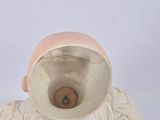 a white vase with a pink hat on top of it