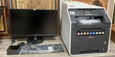 un ordinateur et une imprimante posés l'un à côté de l'autre sur un bureau