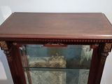 a glass display cabinet with a wooden top and a glass door