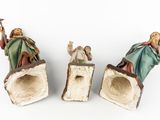 three figurines of jesus, mary, and other figures on a white surface