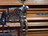 une statue représentant un homme tenant un globe terrestre, à côté d'une statue représentant un cheval