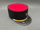 chapeau haut-de-forme noir et rouge avec des bordures dorées sur un fond gris