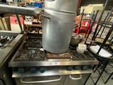 pots and pans are stacked on top of a stove in a kitchen