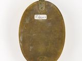 a brass toilet seat with a tag on it