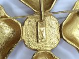a gold flower brooch with four petals on it