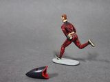 a figurine of a man on a surfboard next to a shark fin