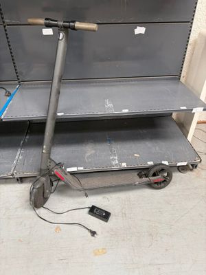 une trottinette posée par terre devant une étagère