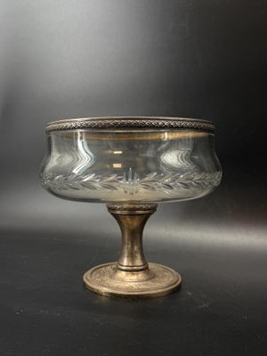 an antique glass bowl with a gold rim on a black surface