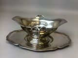 a silver plate with a silver saucer on it