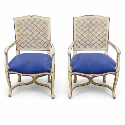 pair of blue upholstered chairs with gold trim and blue upholstered cushions