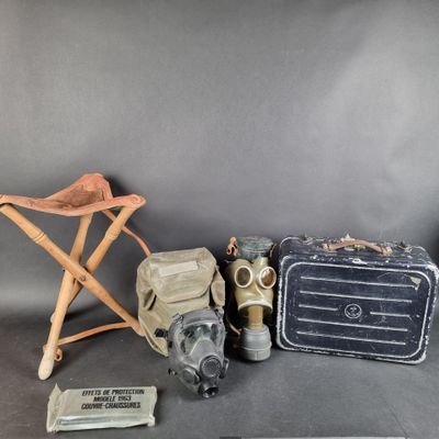 trois valises et un masque à gaz sont posés les uns à côté des autres