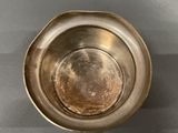 a close up of a metal bowl on a gray surface