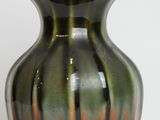 a green and brown vase sitting on a white surface
