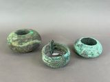 three green vases sitting on top of a table next to each other