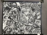 black and white aerial photograph of a city with a river running through it
