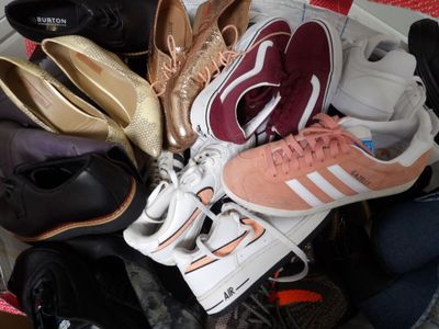 many pairs of shoes that are sitting in a basket