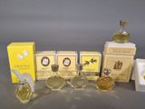 several small bottles of perfume sitting on top of boxes next to each other
