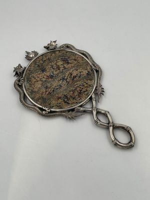 a close up of a coin on a chain on a white surface