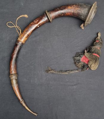 an old horn with a red ribbon on it