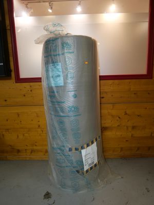 un gros rouleau de plastique enroulé autour d'un chauffe-eau