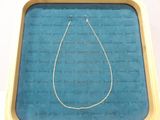 un collier exposé dans une boîte posée sur une table