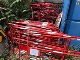 a lot of red shopping carts in front of a blue dumpster