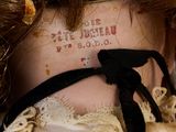 a close up of a doll ' s neck with a tattoo on it