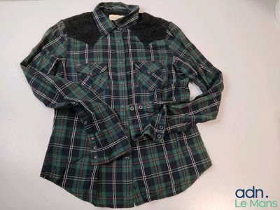 a close up of a plaid shirt on a white surface