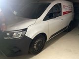 a white van parked in a garage with a man standing next to it