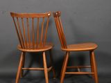 deux chaises en bois placées l'une à côté de l'autre sur un fond gris