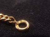 a close up of a gold chain on a black cloth