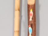 a wooden stick with a picture on it next to a wooden stick with a picture on it