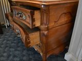 a wooden dresser with a drawer on top of it