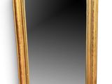 un miroir encadré d'or sur un mur blanc avec un fond blanc
